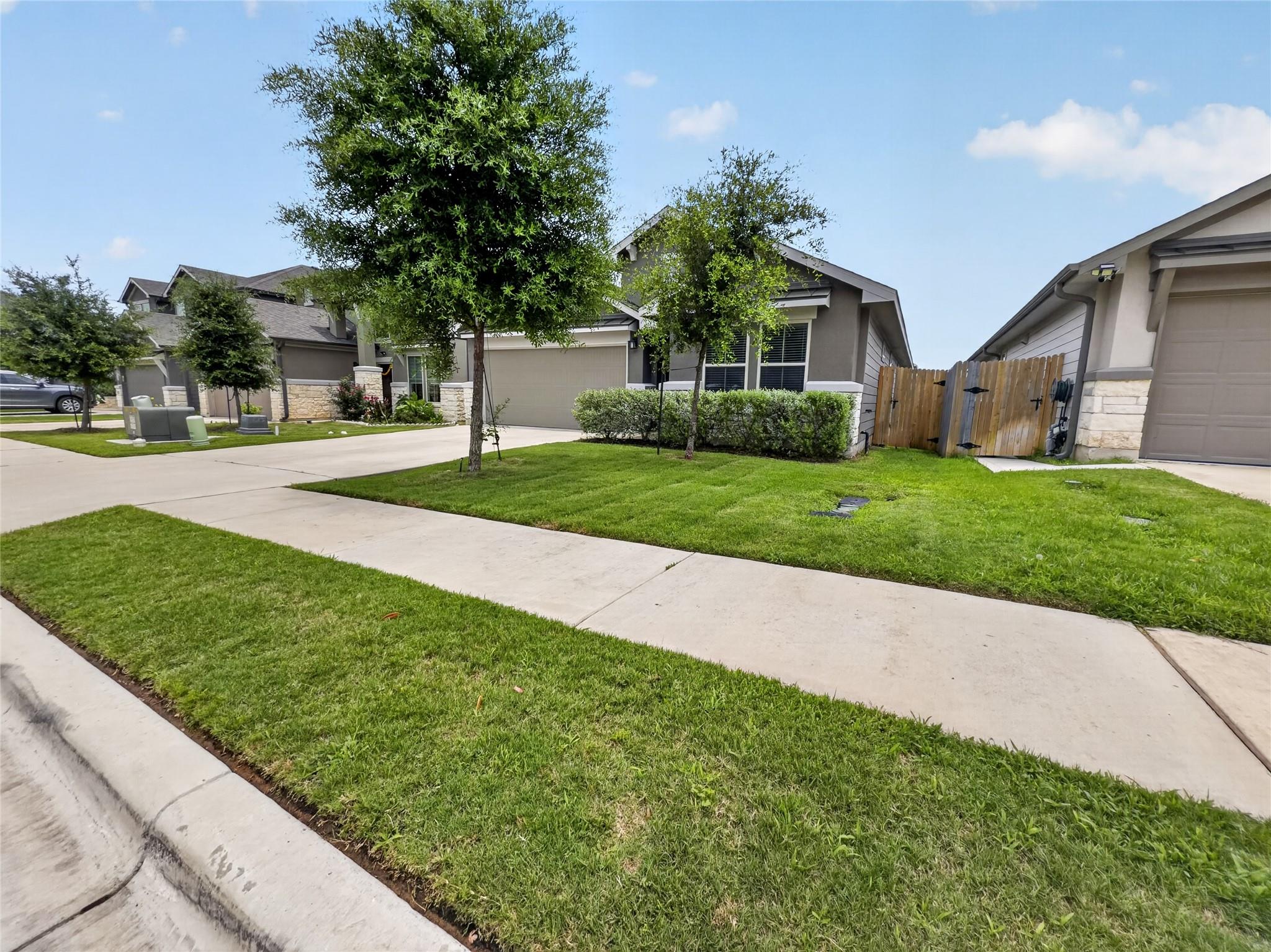 A well-maintained lawn and sturdy fence define th