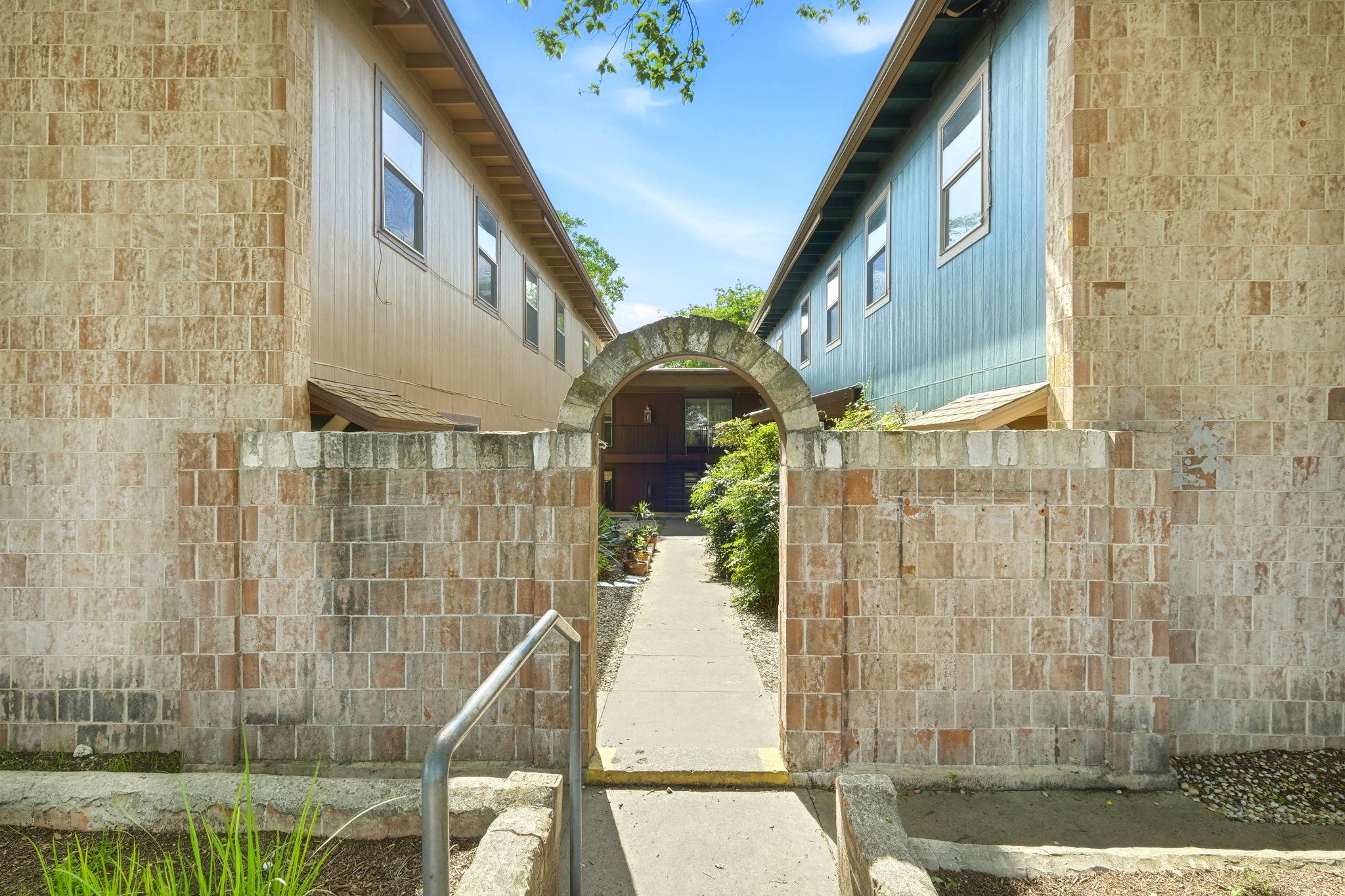An inviting stone archway leads to a private cour