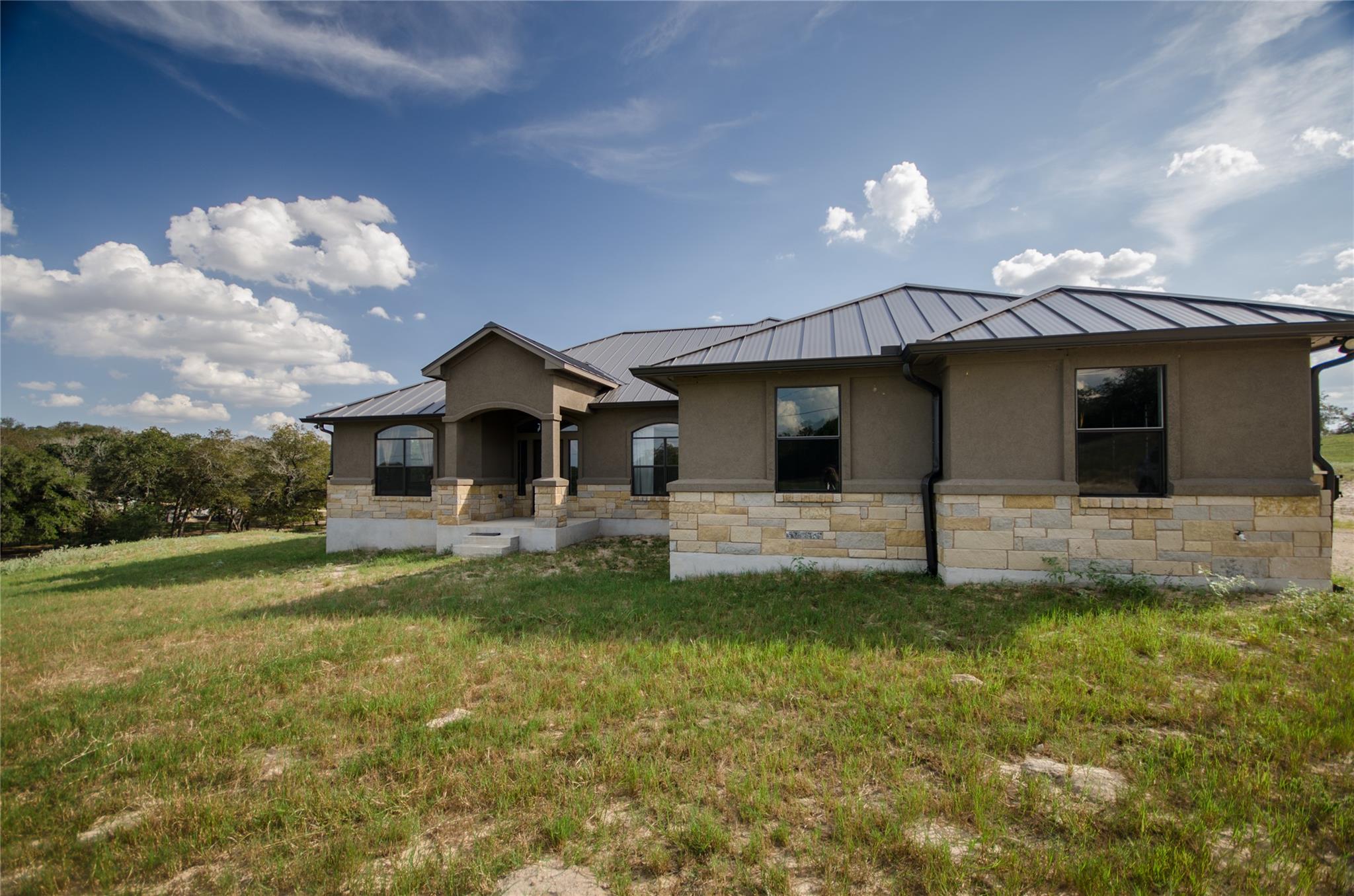 Natural stone accents and a durable metal roof de