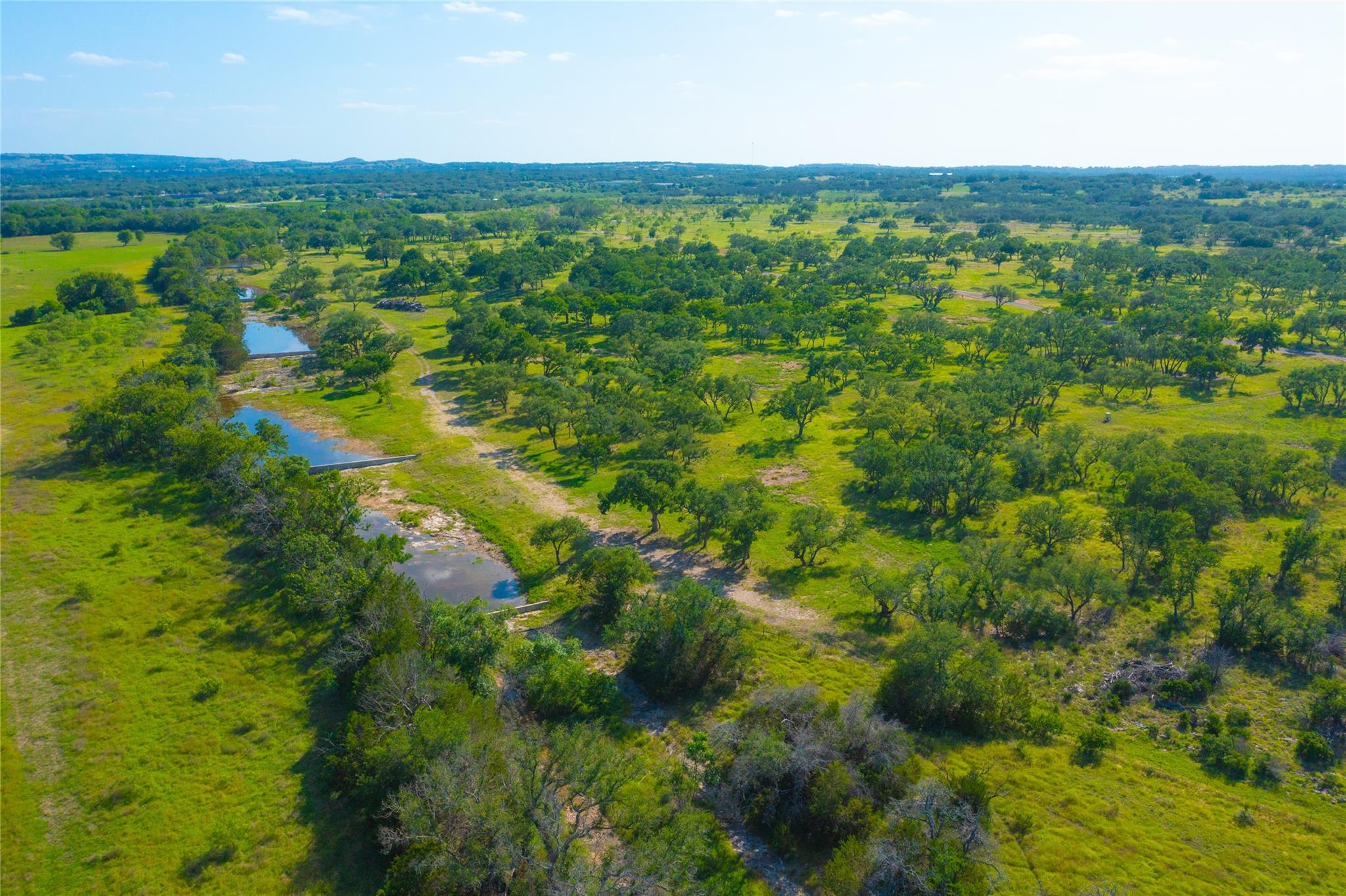 Vast green acreage featuring a winding creek and 