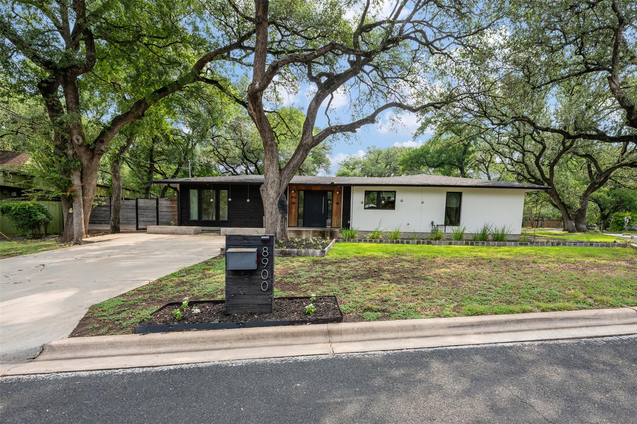 Mature trees frame this modernized ranch home, of