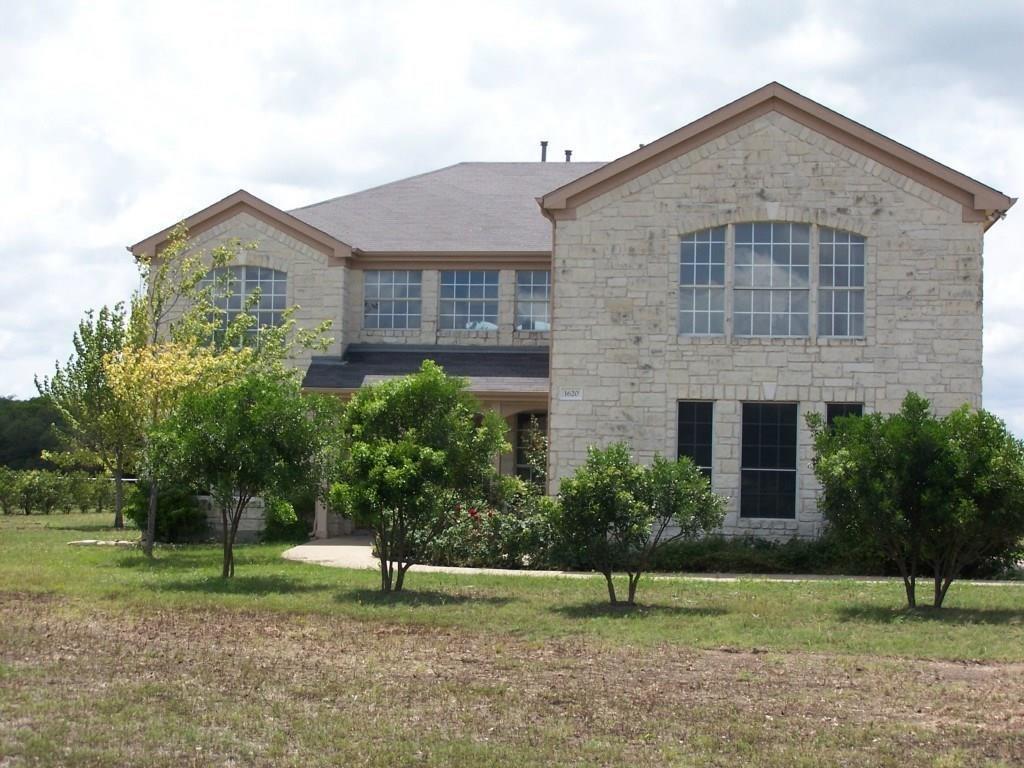 A stone-clad residence with arched windows stands