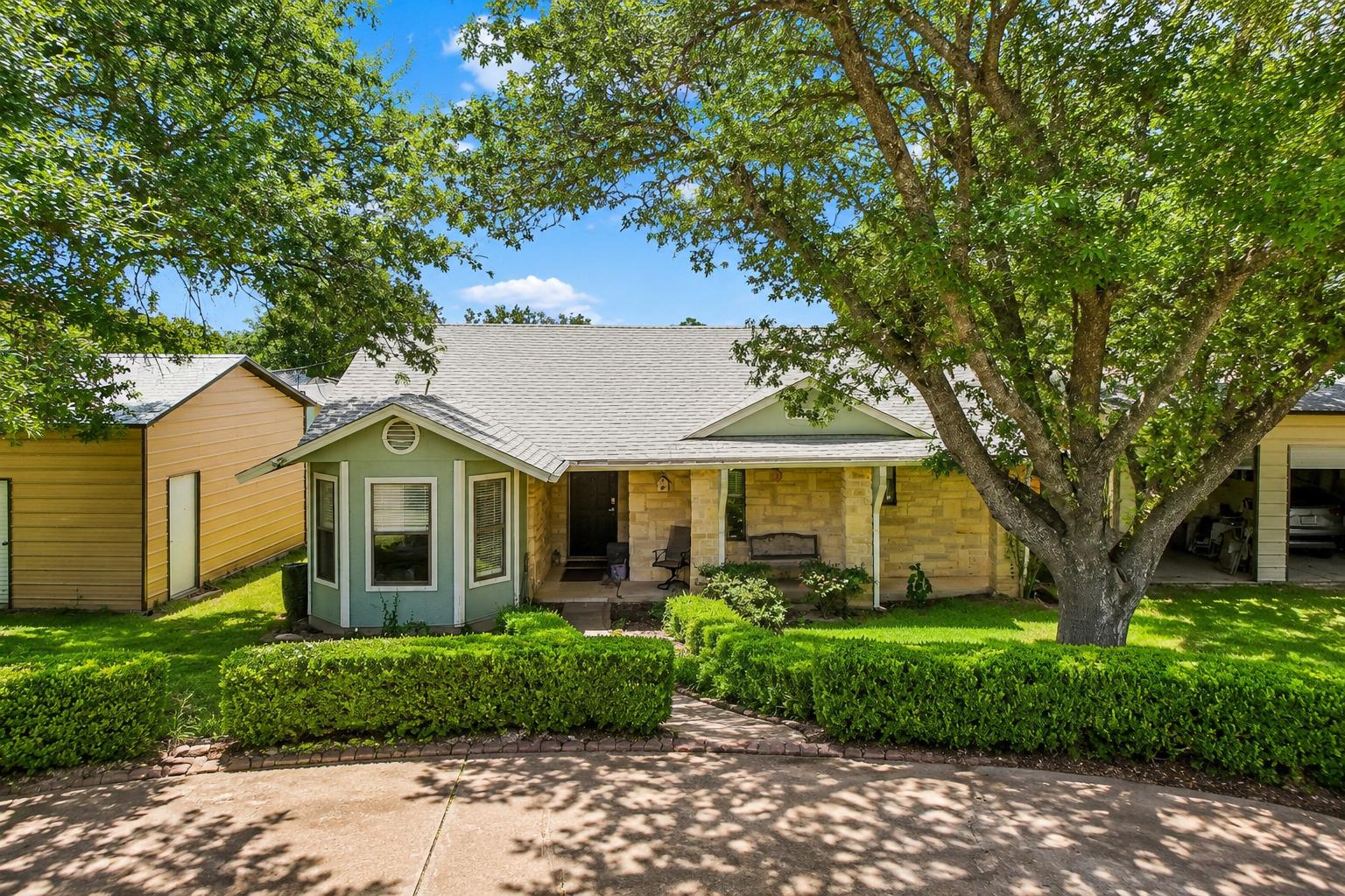 Mature trees canopy this inviting home, framed by