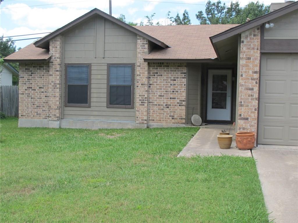 A well-maintained lawn greets this inviting brick