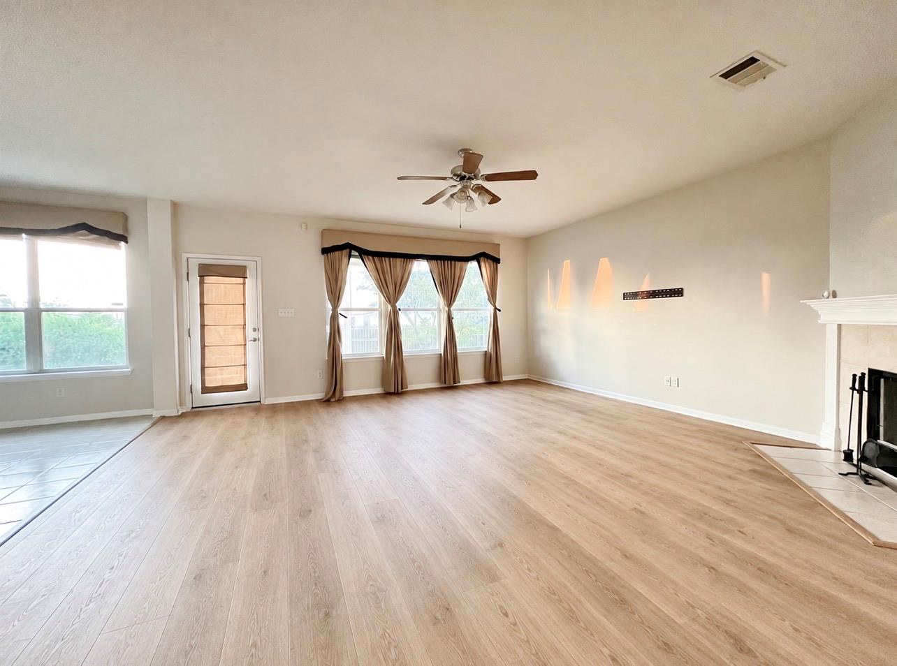 A spacious layout showcases light-toned wood floo