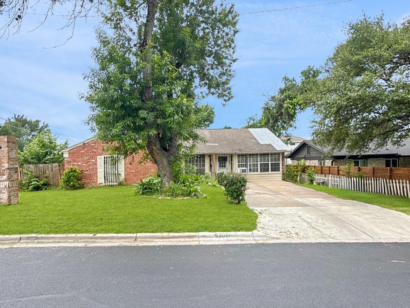 Mature trees frame this traditional brick residen