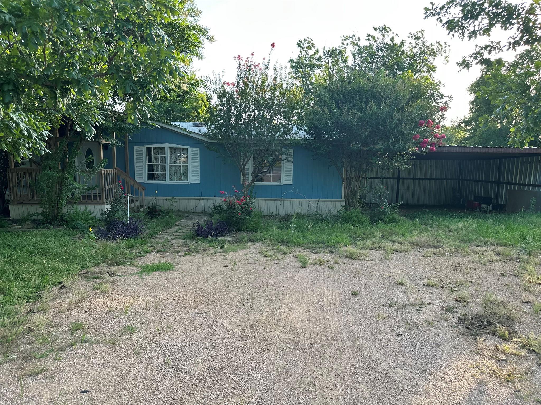 A charming blue home with white trim offers a wel
