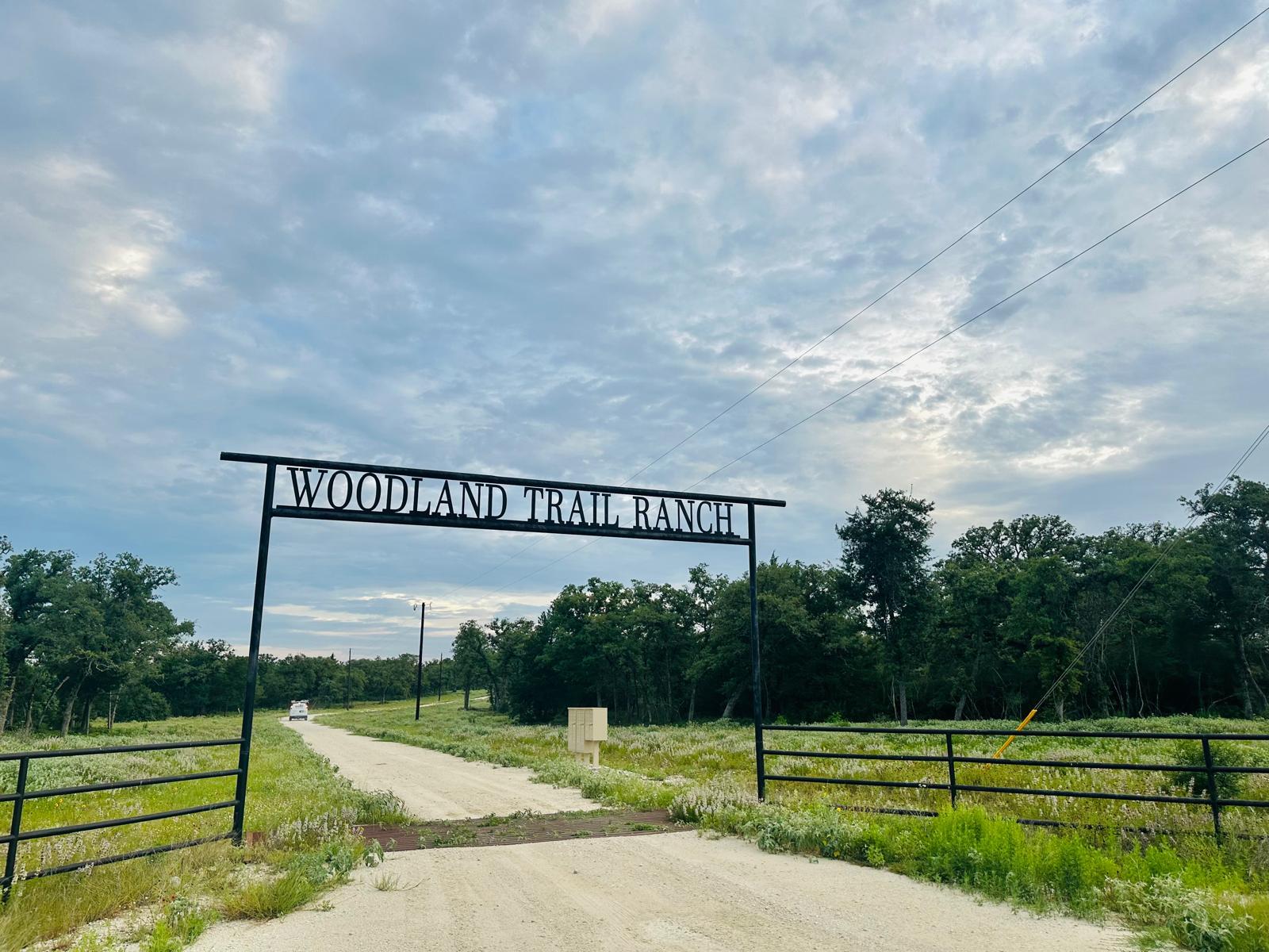A private ranch entry with fencing and a long gra