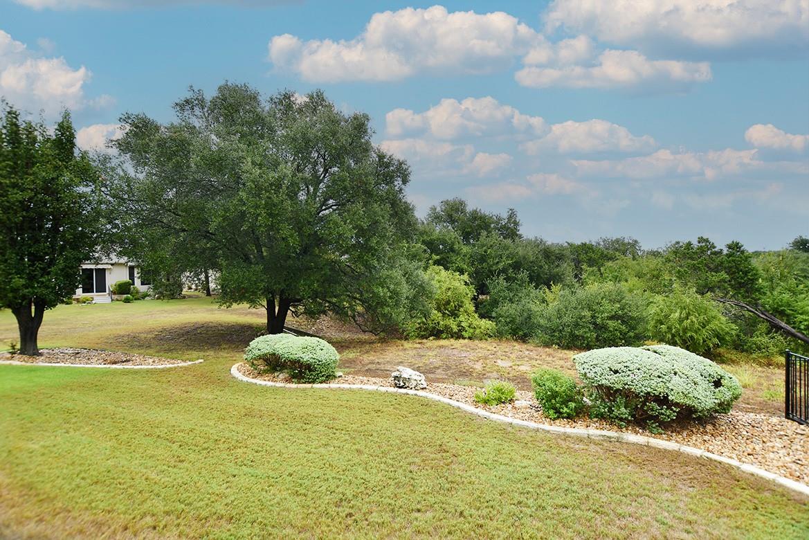 Lush landscaping and mature trees frame this expa