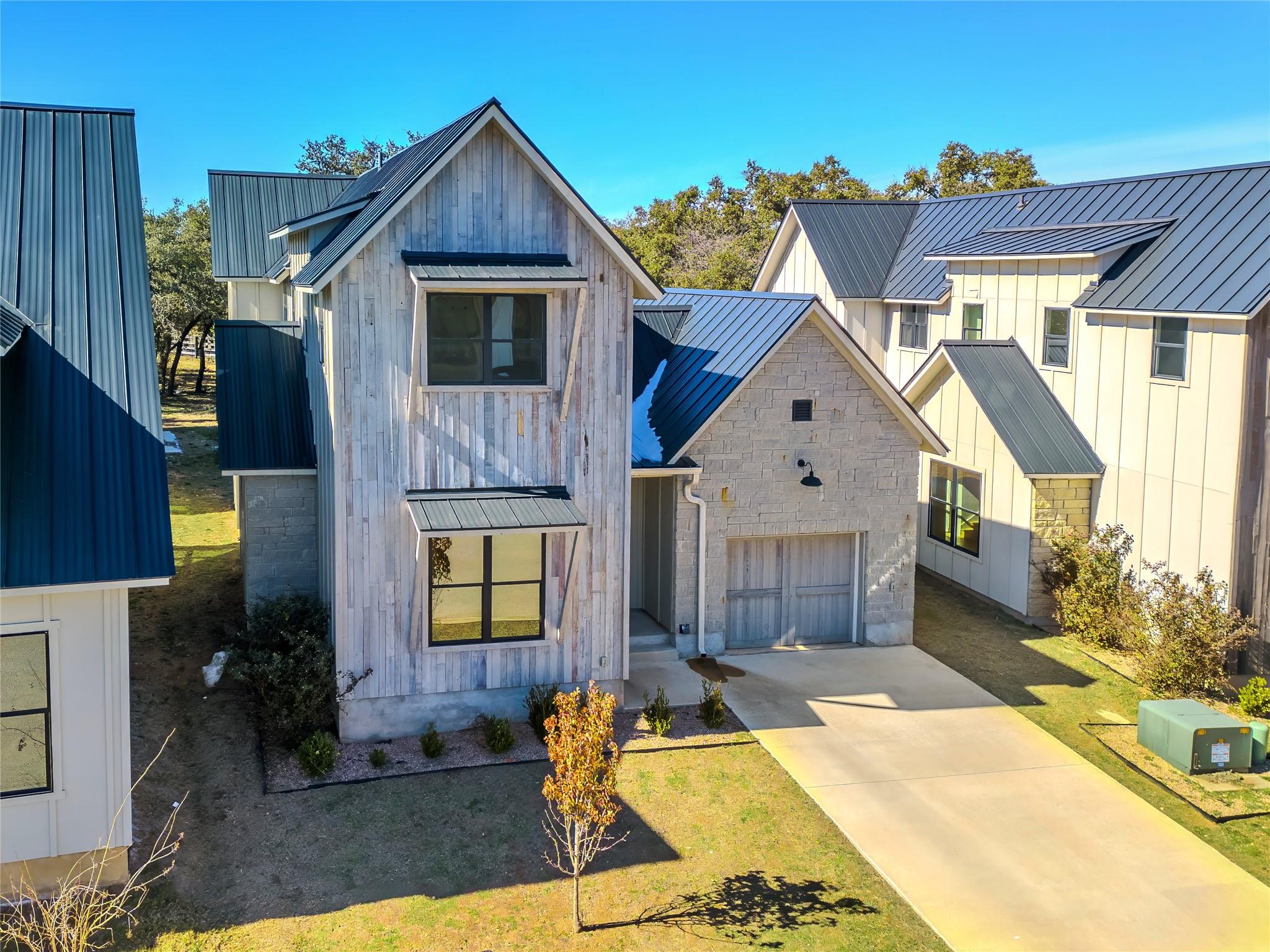 Modern rustic facade boasts a metal roof and an a