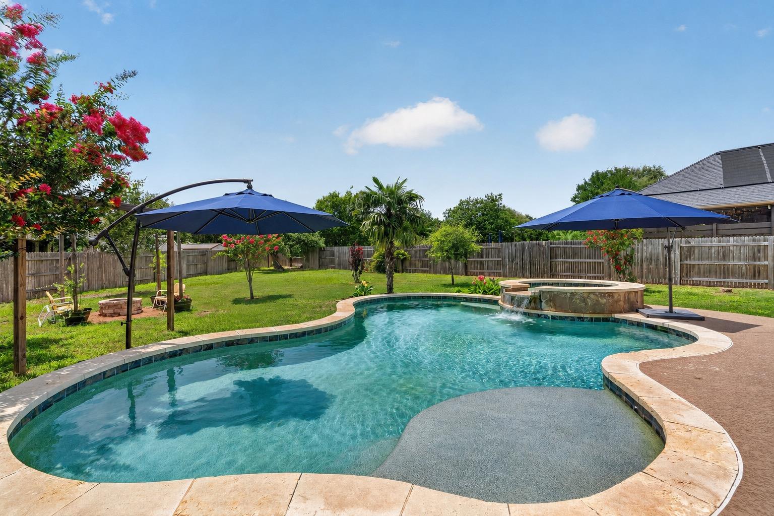 An inviting backyard oasis offers a freeform pool