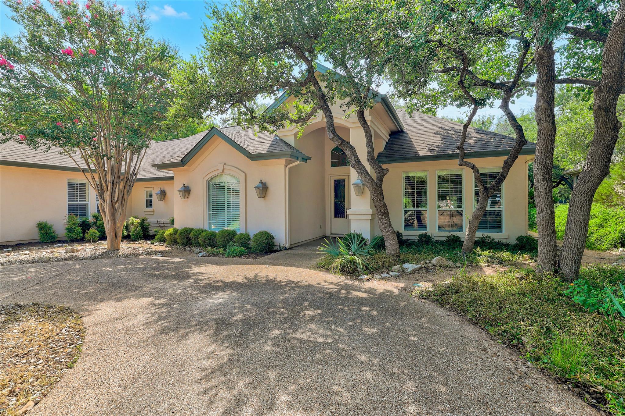 Mature trees frame this inviting residence, showc
