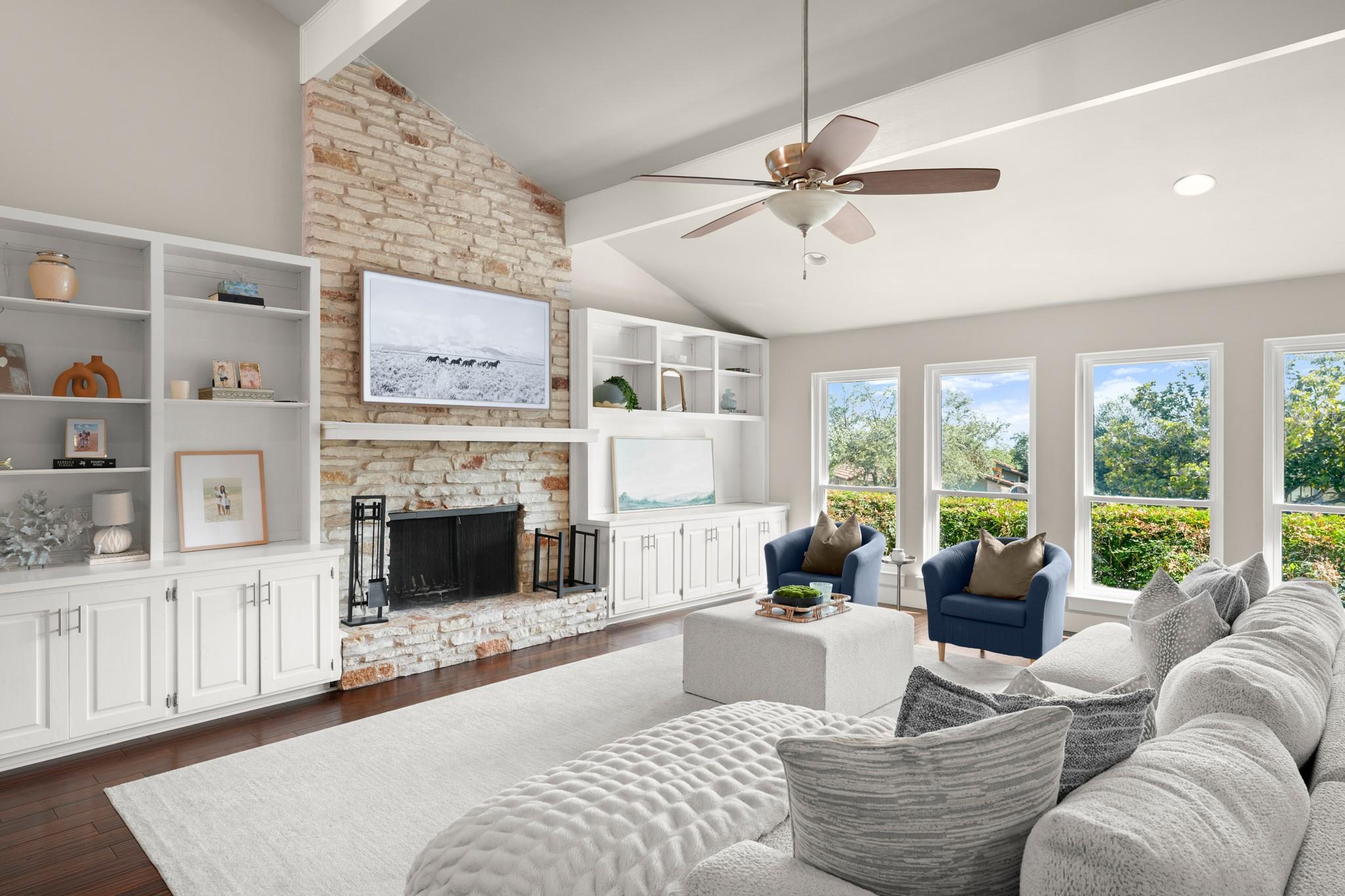 A striking stone fireplace anchors this airy livi