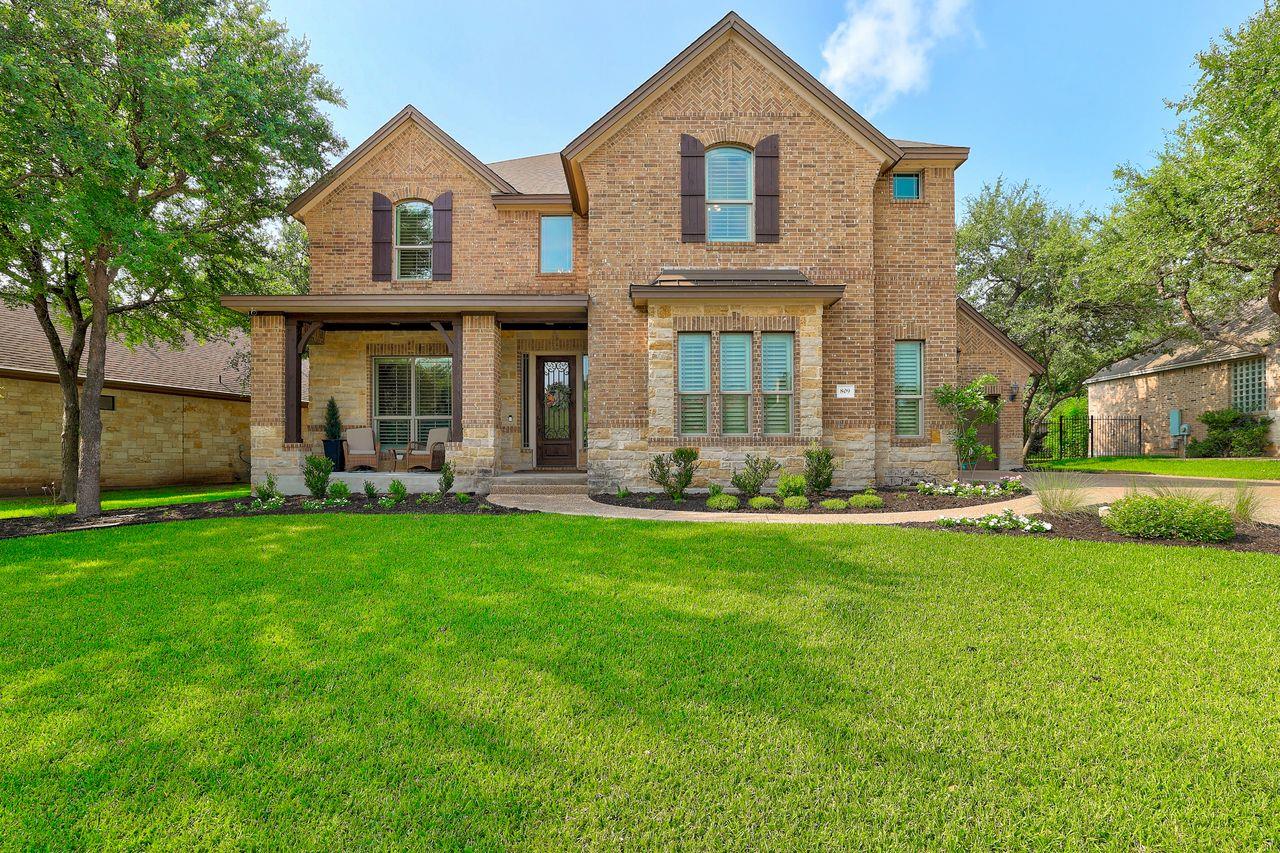 A well-manicured lawn leads to a charming brick a