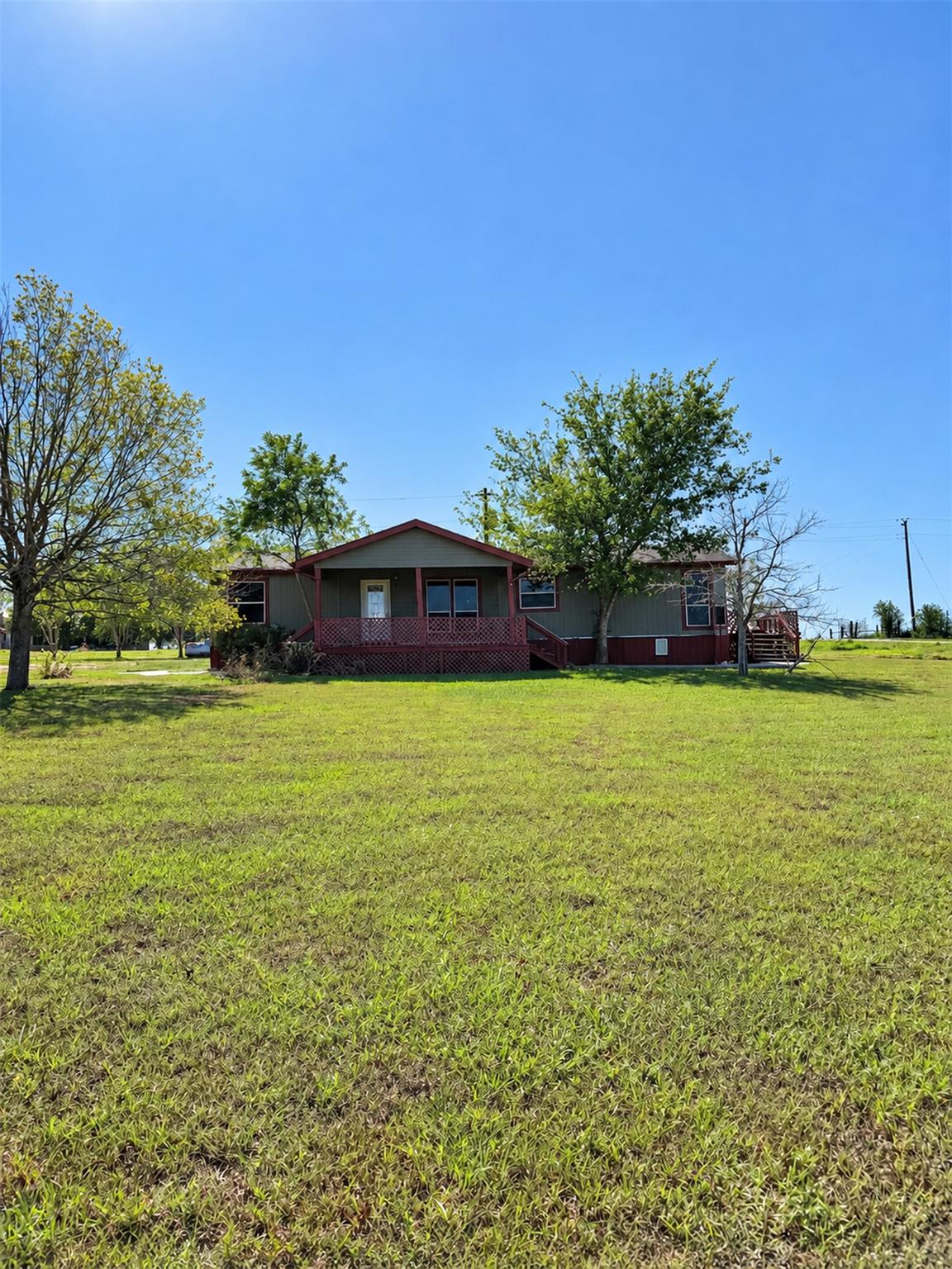 A spacious green lawn surrounds this country home