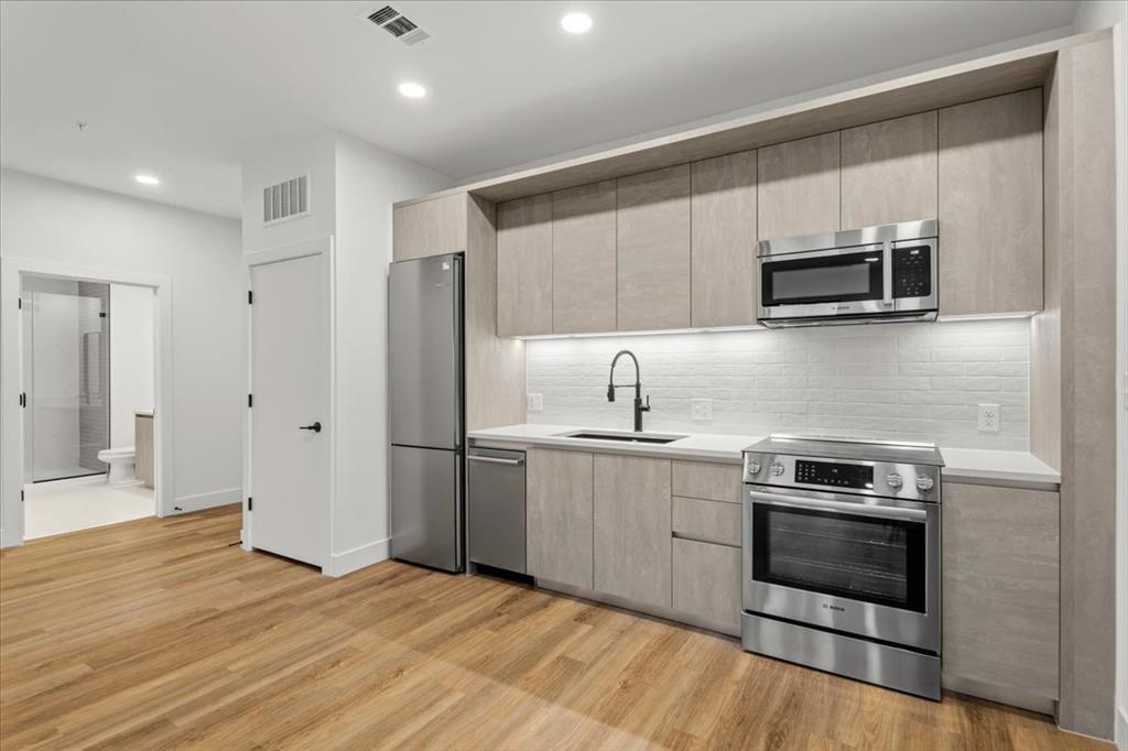 A sleek, modern kitchen boasts stainless steel ap