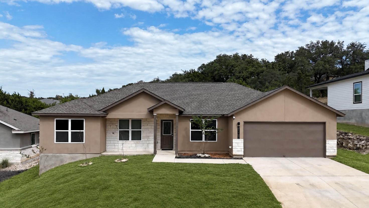 A well-maintained lawn and paved driveway lead to