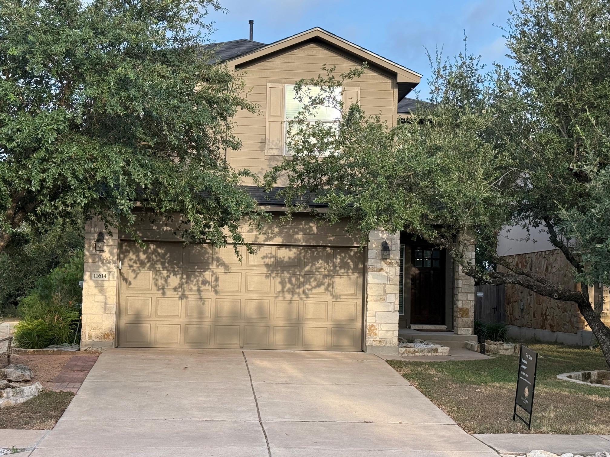 Mature trees shade a classic two-story exterior f