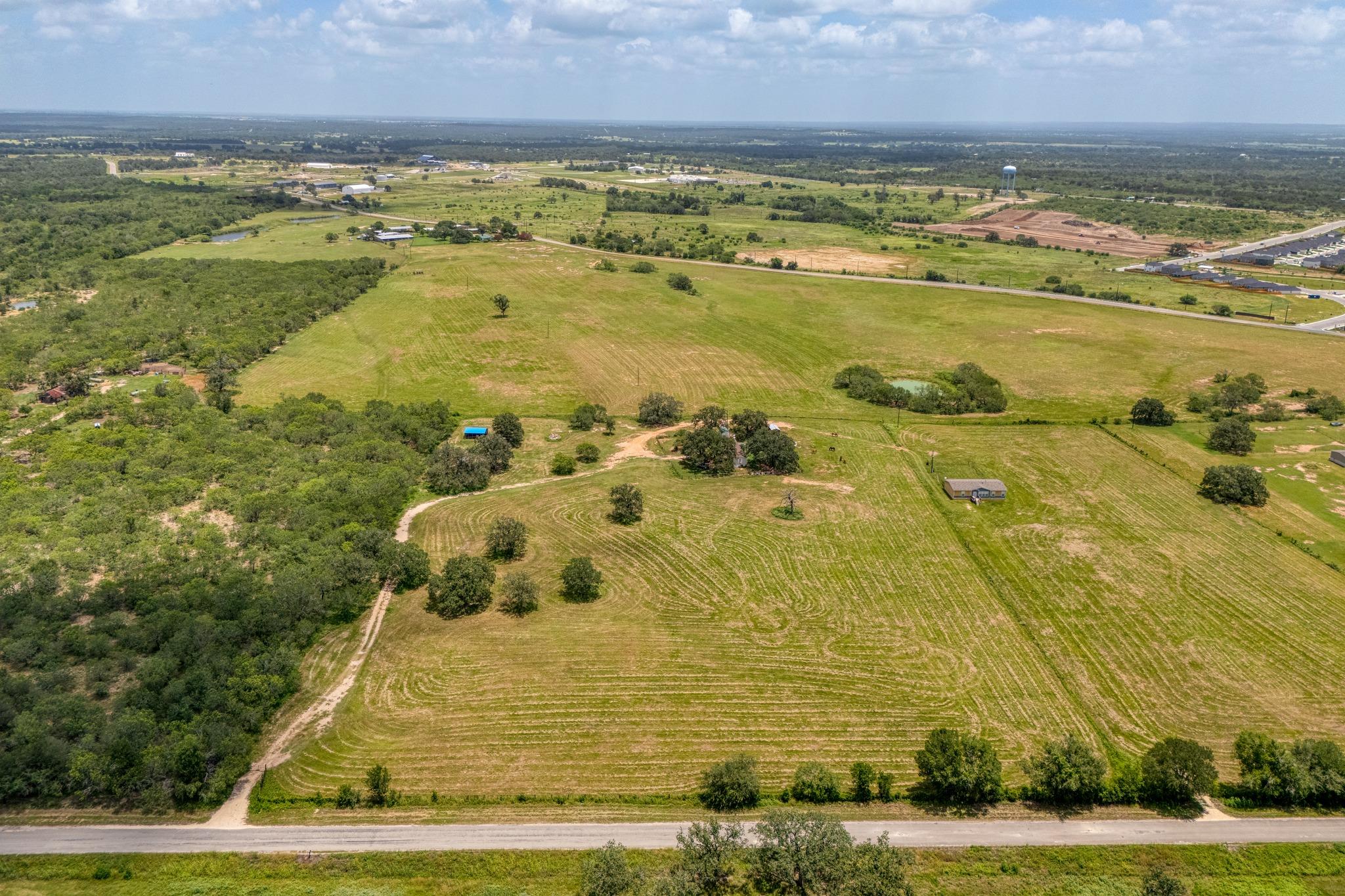 An aerial panorama reveals verdant fields bordere