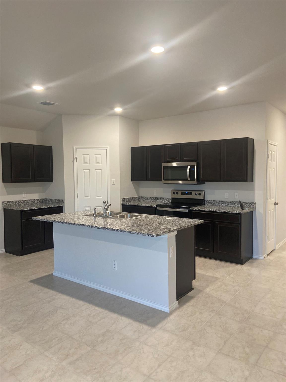 A well-appointed kitchen features dark cabinetry,