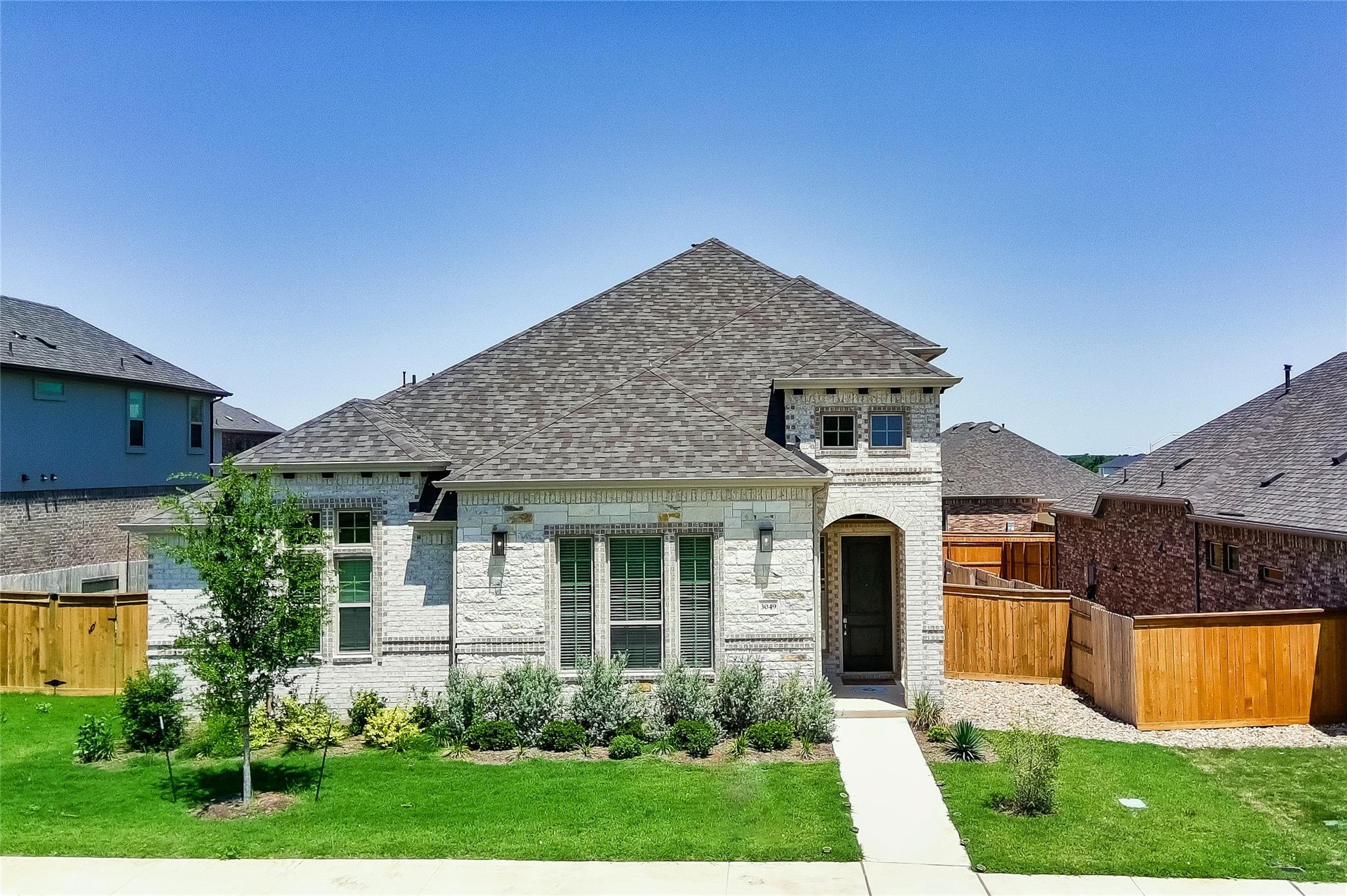A well-maintained lawn and shrubbery complement t