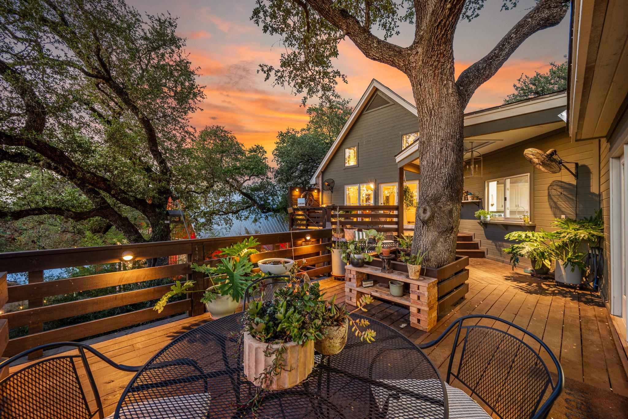 A spacious wooden deck encircles mature trees to 