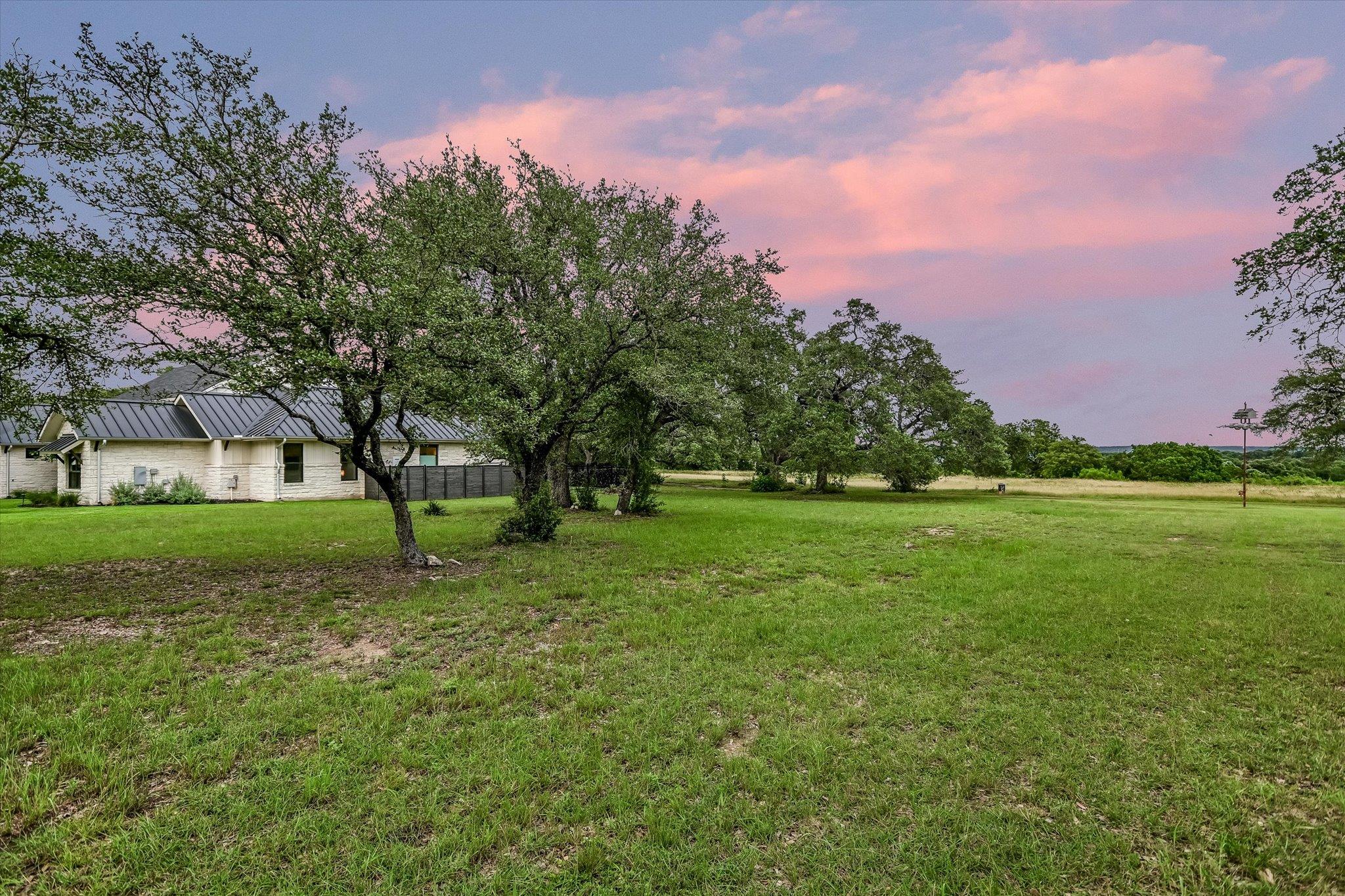 A verdant, open lot awaits with mature trees and 