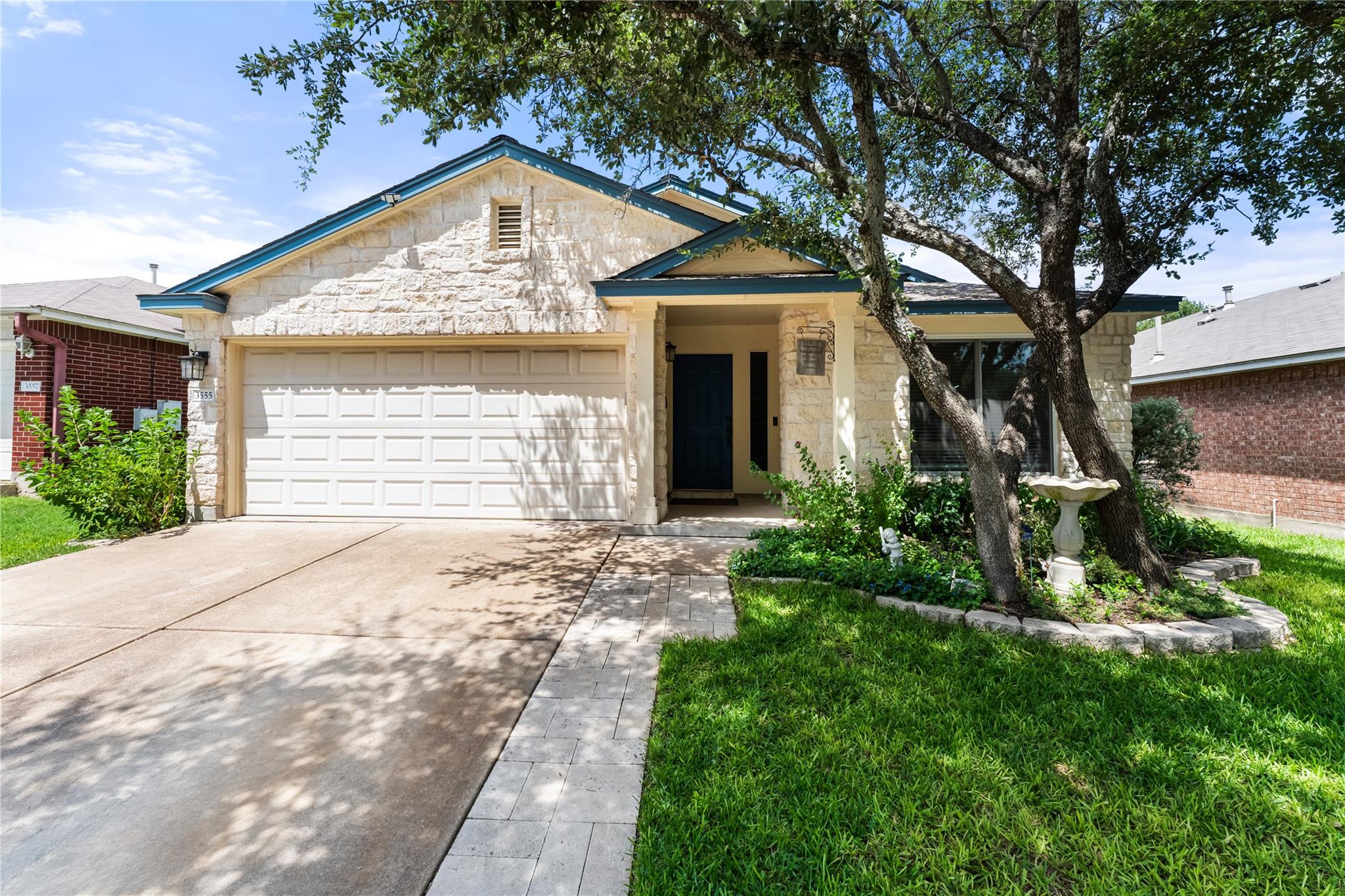 A welcoming stone facade with an attached garage 