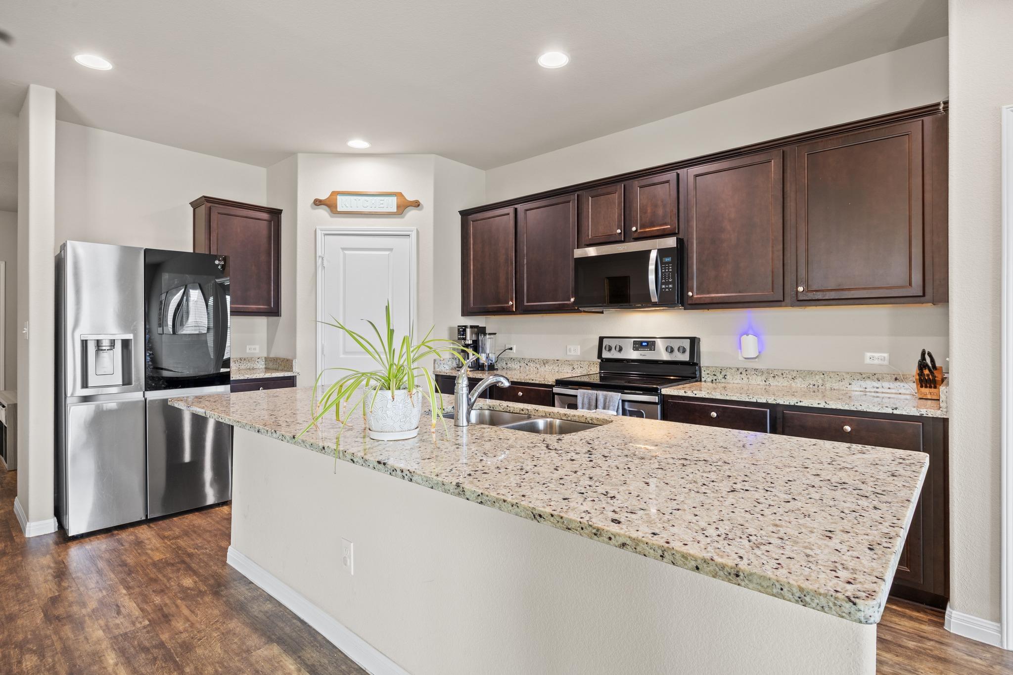A contemporary kitchen features rich cabinetry, s