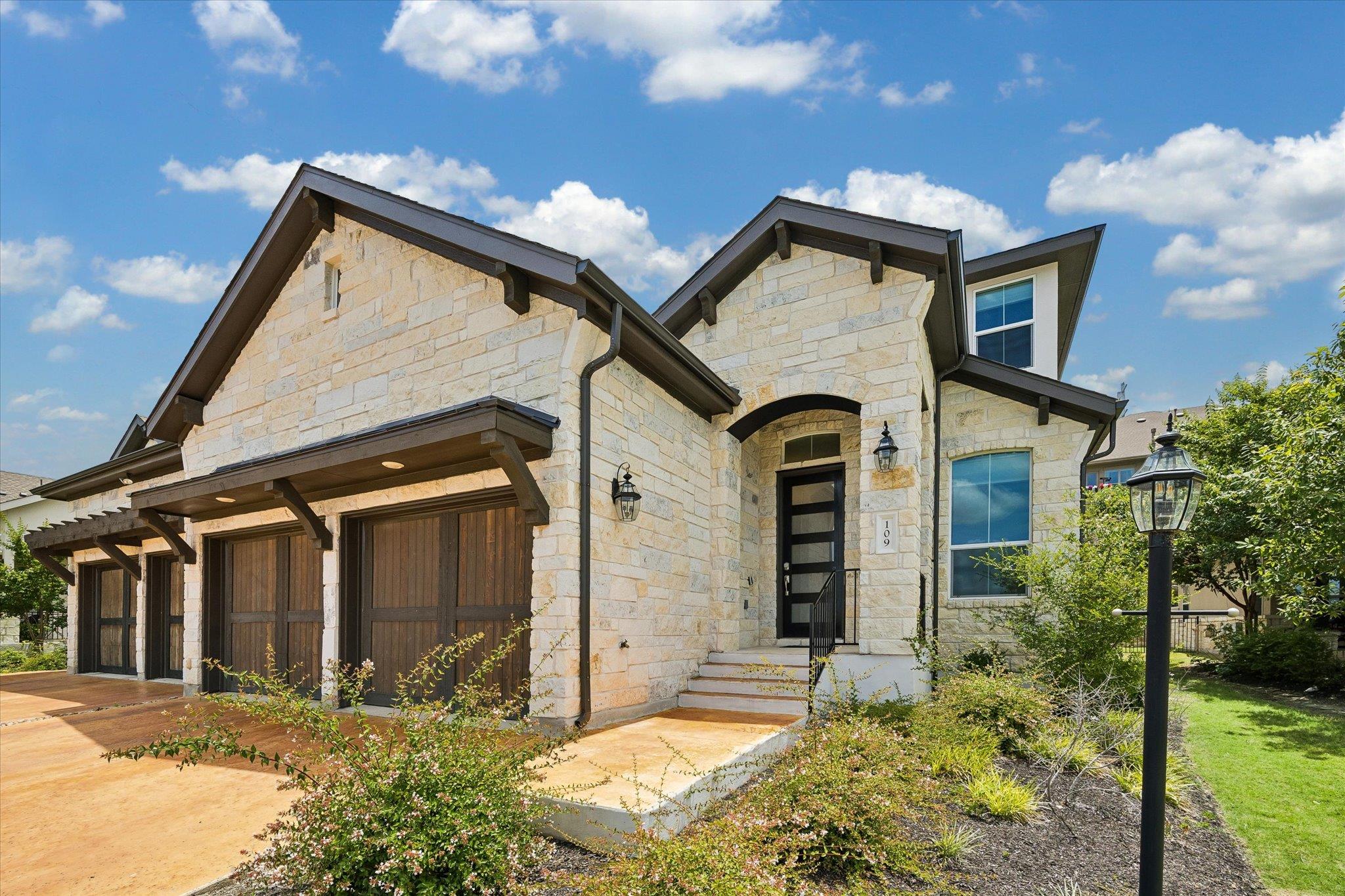 A striking stone exterior with dark wood garage d
