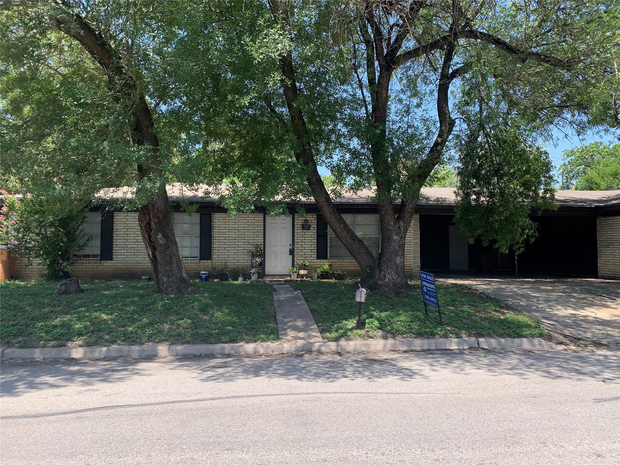 Mature trees shade this charming brick home with 