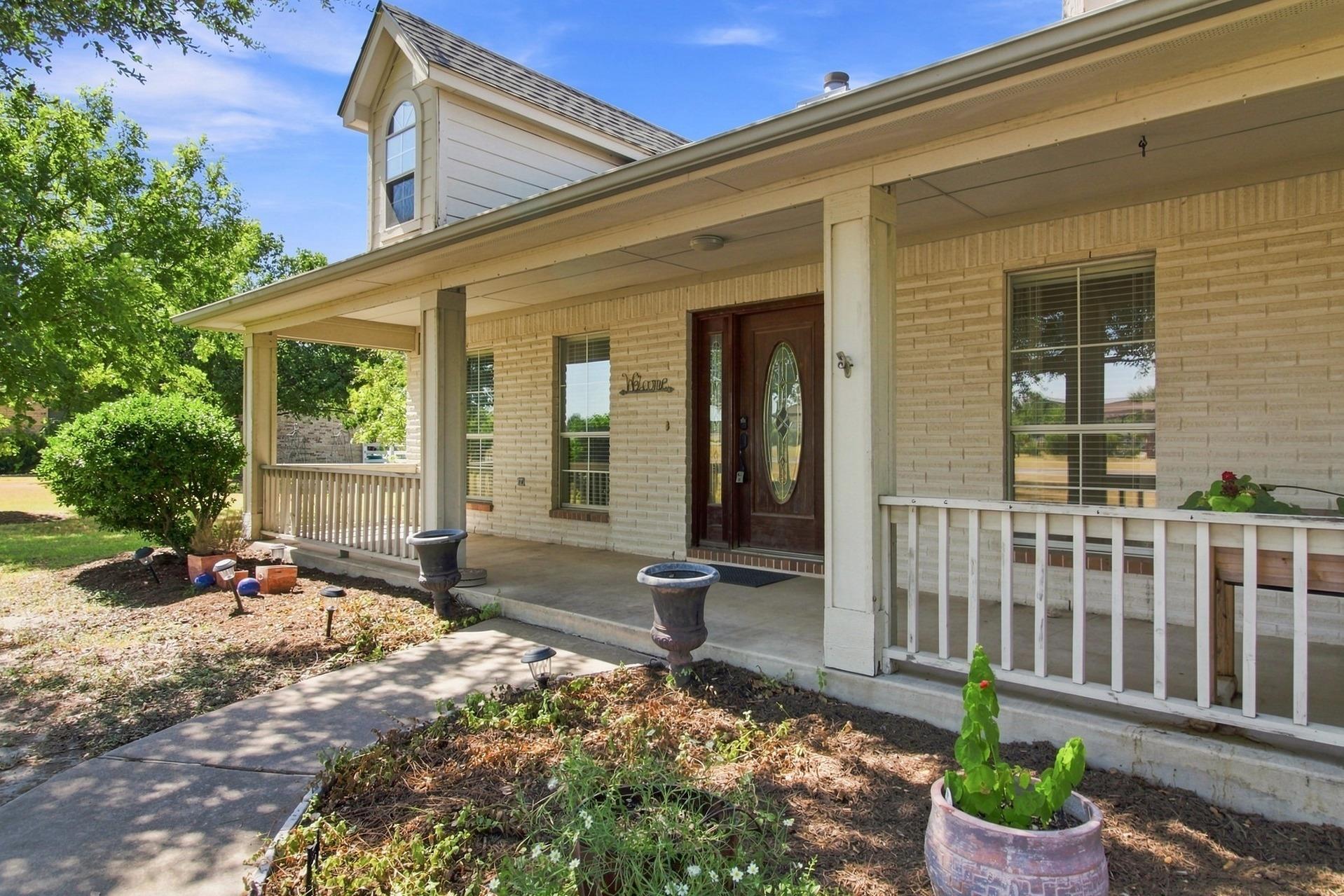 A deep covered porch with classic brick detailing