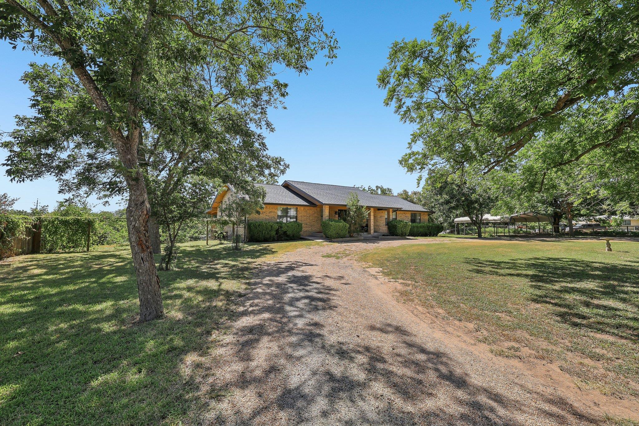 A long, winding driveway leads to this charming b