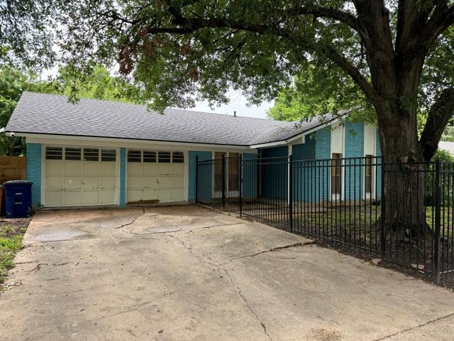 A classic ranch home, graced by a mature tree, of