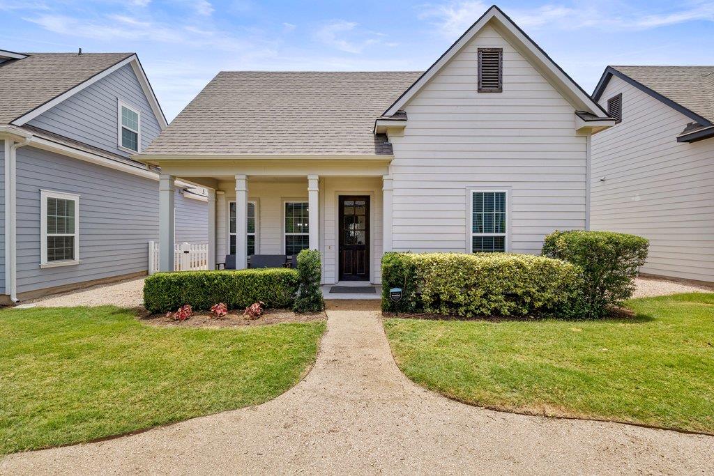 A welcoming gravel path leads to this home, frame
