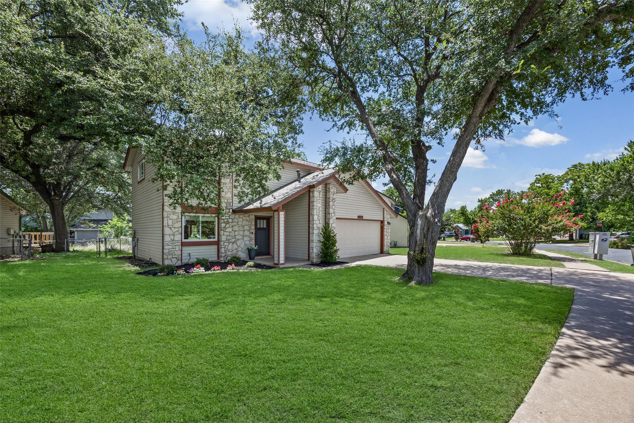 Mature trees shade this charming home with stone 