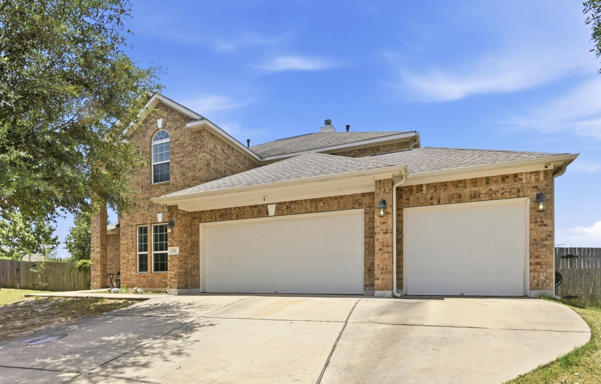 A spacious concrete driveway leads directly to th