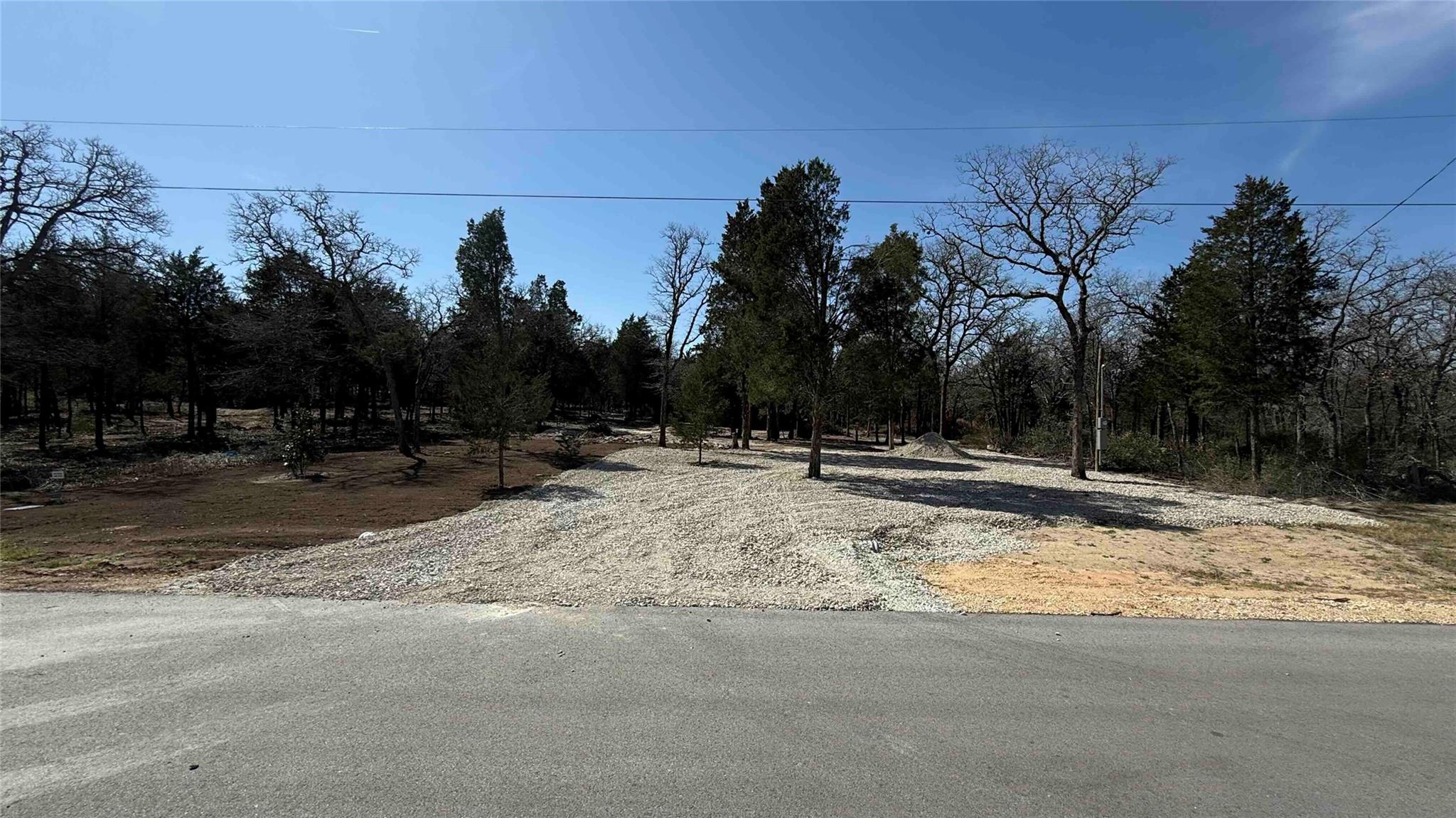 Mature trees frame a spacious, cleared lot, offer