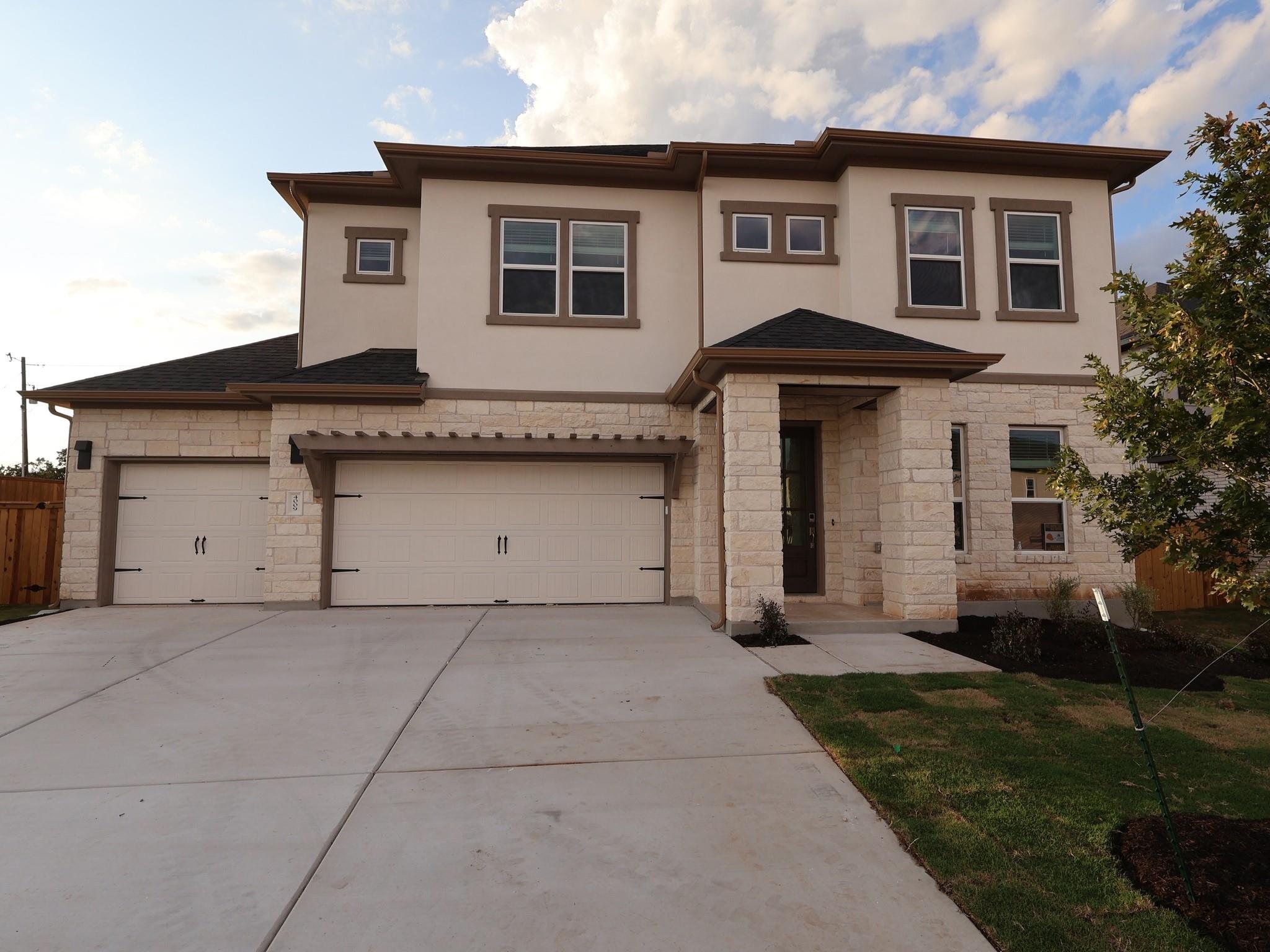 A striking stone and stucco facade frames this ne