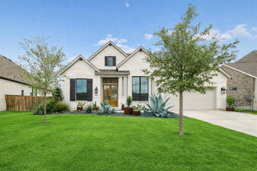 A pristine white brick home with dark shutters an