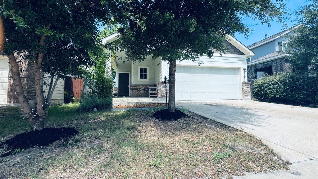 A welcoming facade with a concrete driveway and m