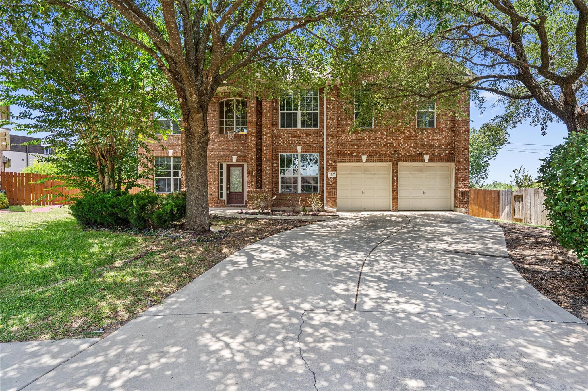 Brick facade home featuring a wide driveway and i