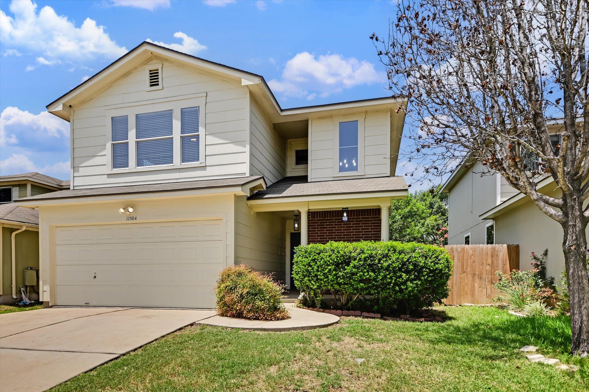 A classic two-story home with a neat lawn and mat