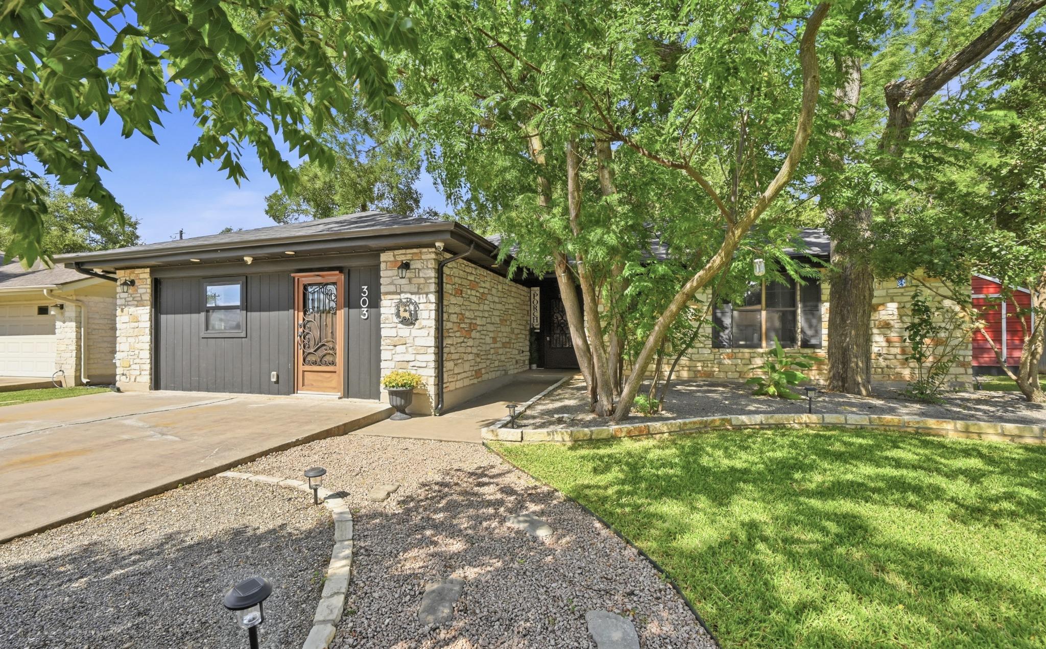 A welcoming stone facade and manicured landscapin