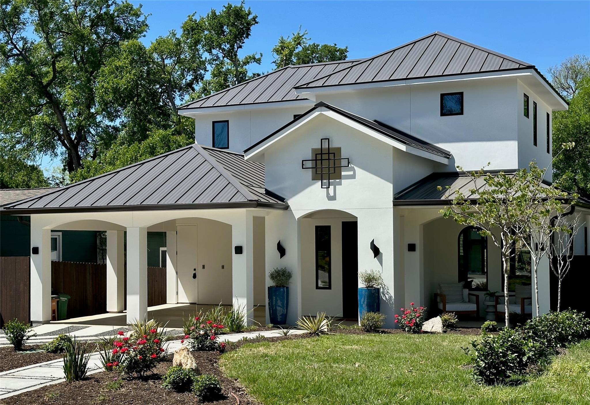Modern white stucco exterior with a dark metal pa