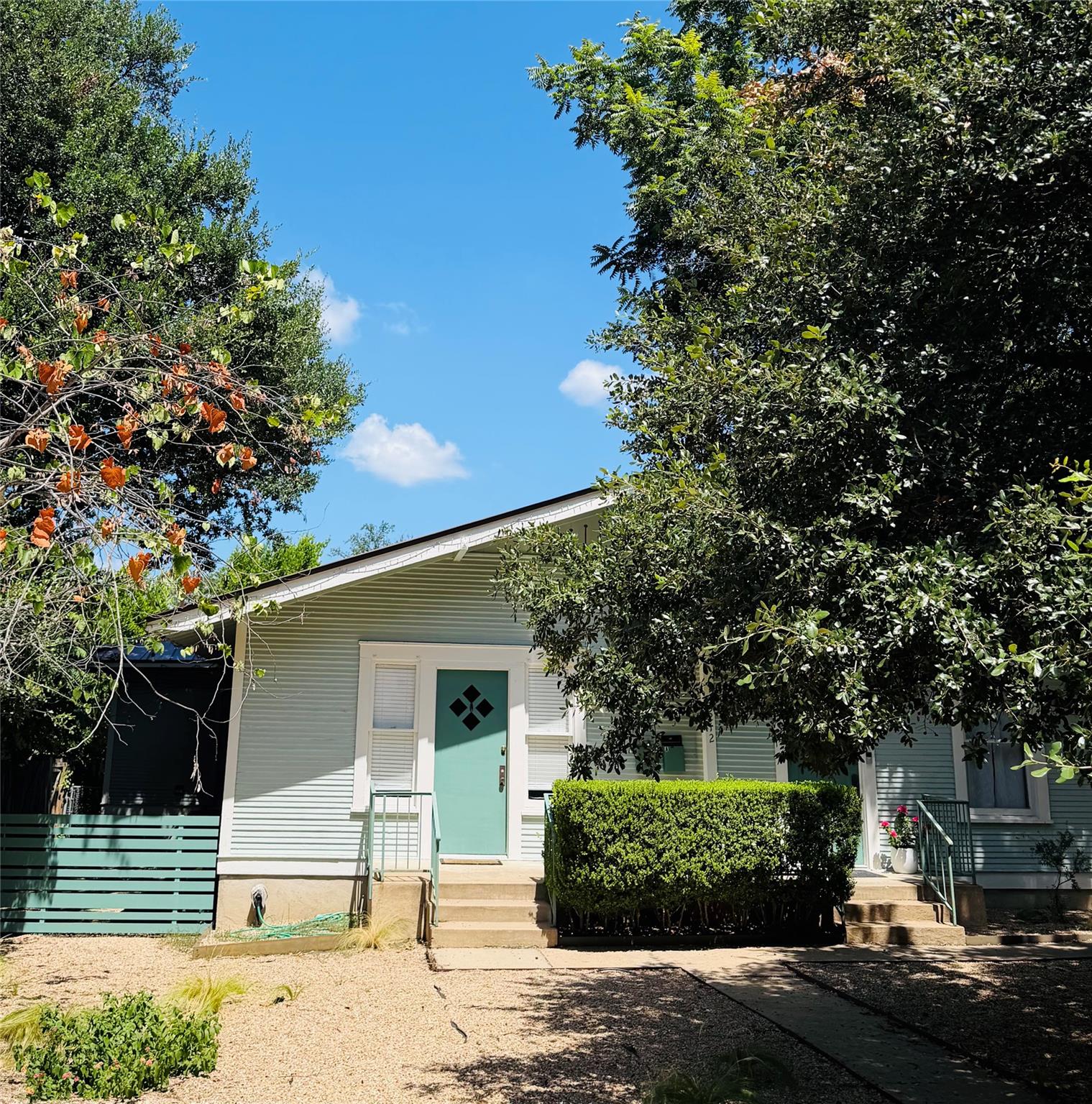 A charming exterior with a bright turquoise door,