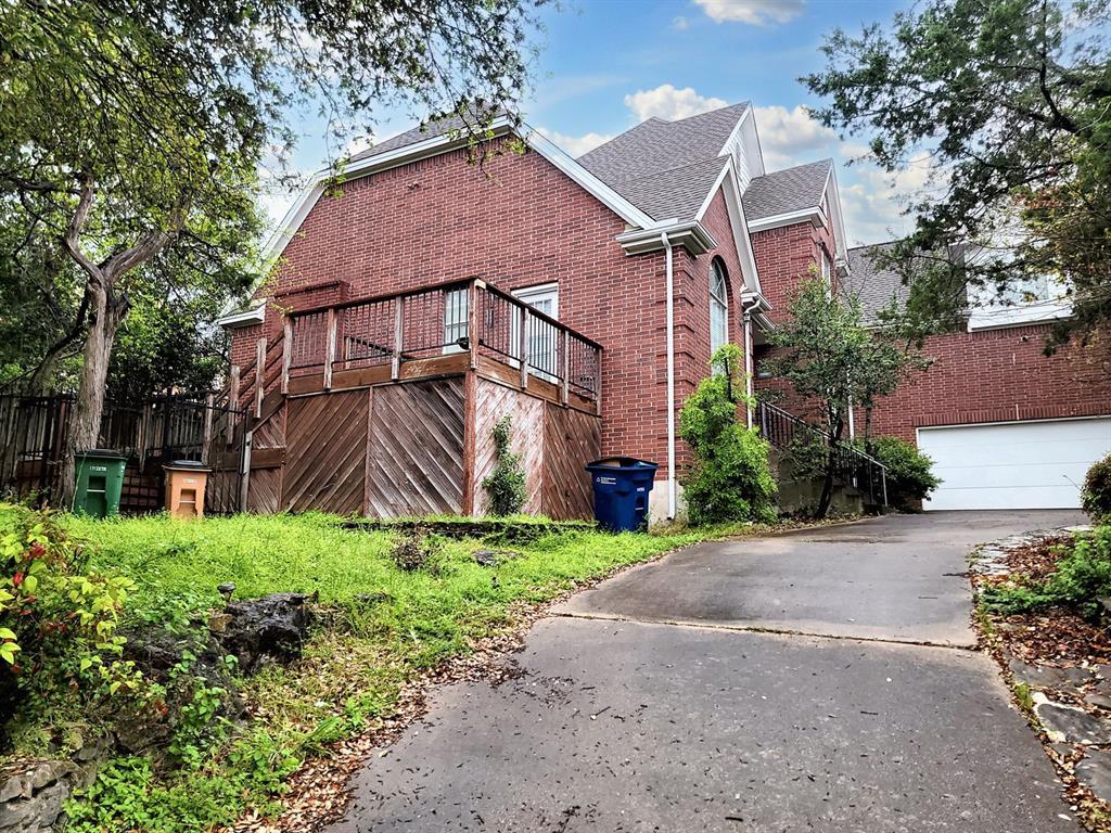 Brick facade home featuring a spacious deck and c