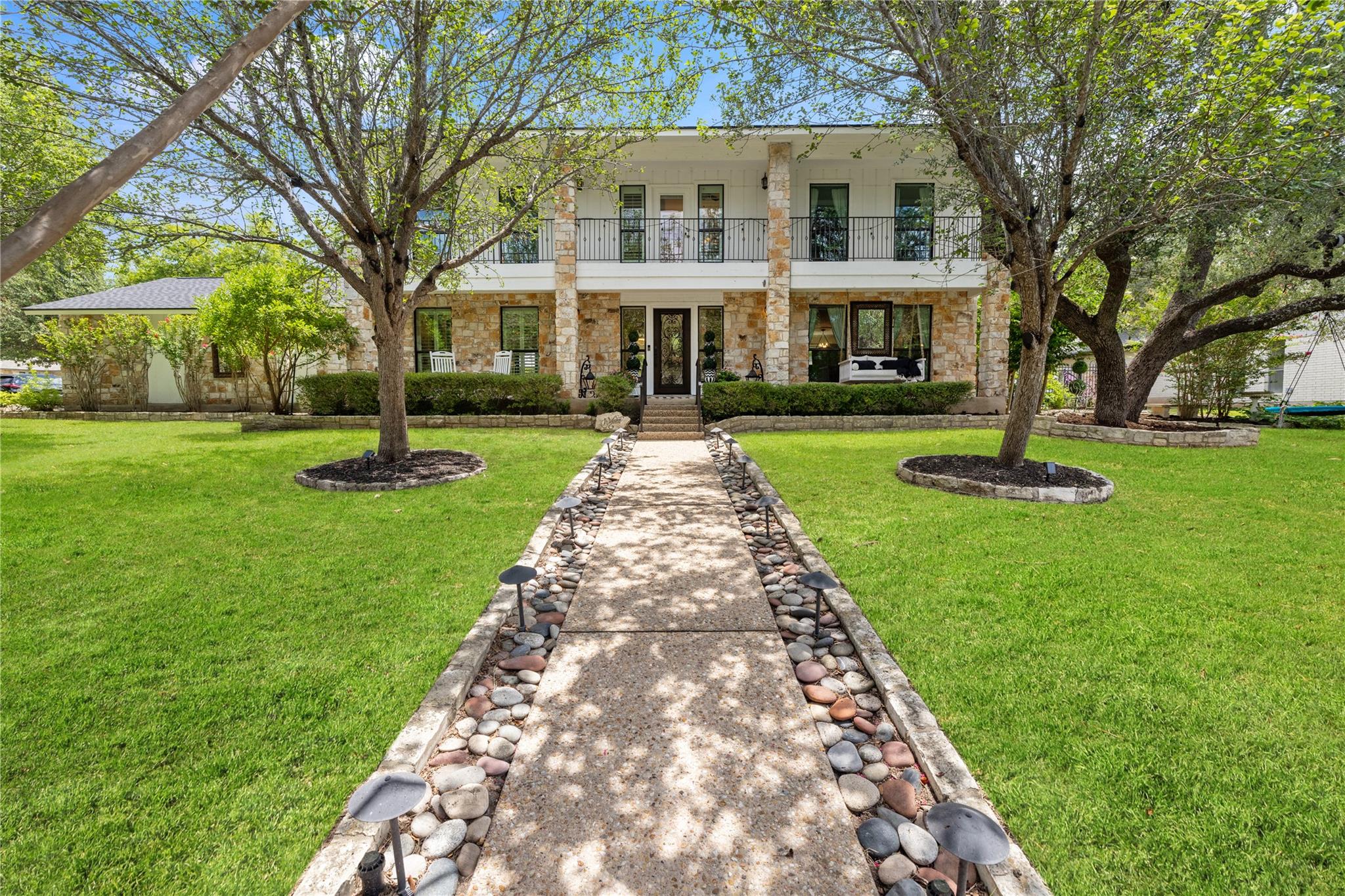 A classic facade with a stone walkway, flanked by