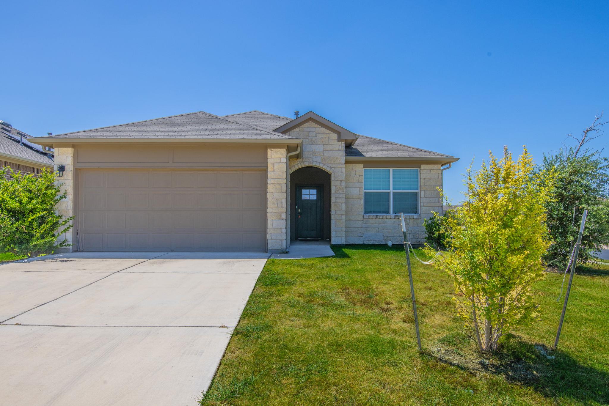 A welcoming stone facade and integrated garage of