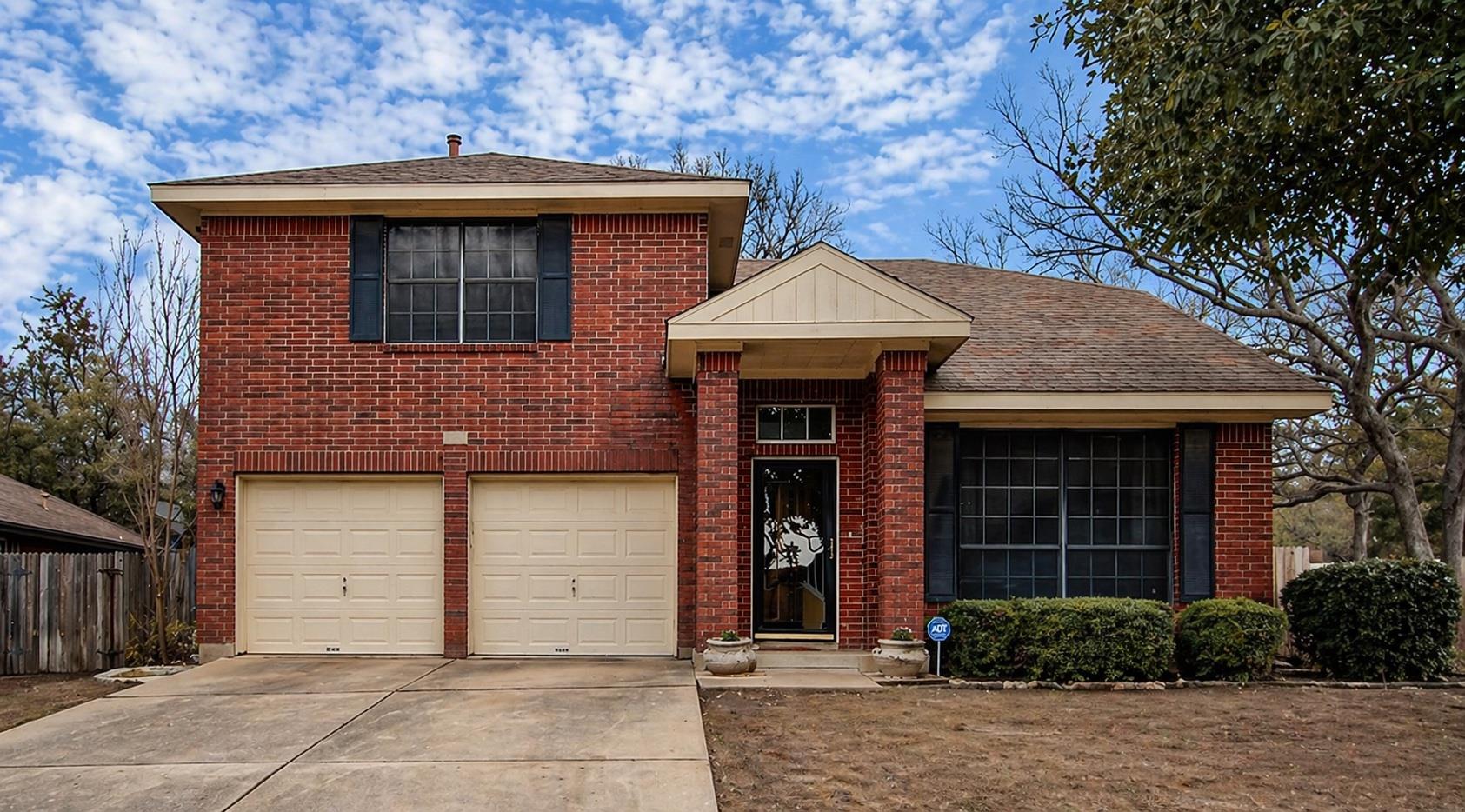Red brick facade with a prominent two-car garage